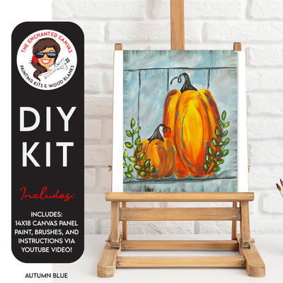 Autumn Blue DIY Paint Kit with a blue wood plank background, 2 harvest orange pumpkins in front with greenery